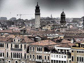 Overview of Venice's rooftops and towers on a foggy day, church towers and historic buildings on a