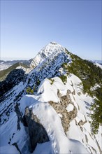Mountain ridge of the Aiplspitz with summit cross, snow-covered mountain landscape with mountain