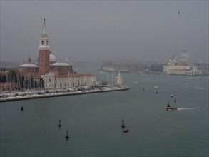 View of the San Giorgio Maggiore church and the lagoon in Venice at foggy dusk, church towers and