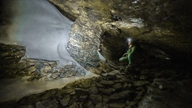 Hiker explores Obstans ice cave in Alta Pusteria, Carnic Alps, East Tyrol, Austria, Europe