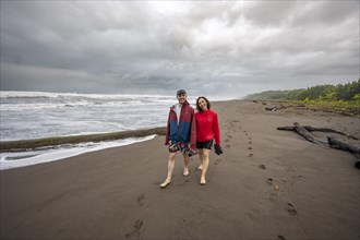 Young couple walking on the sandy beach by the sea, beach on the Caribbean coast, Tortuguero