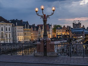 Blue hour with historic houses by the river with old lanterns, Ghent, Belgium, Europe