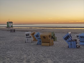 Beach at sunset with colourful beach chairs and calm sea, beautiful sunset on the beach of an