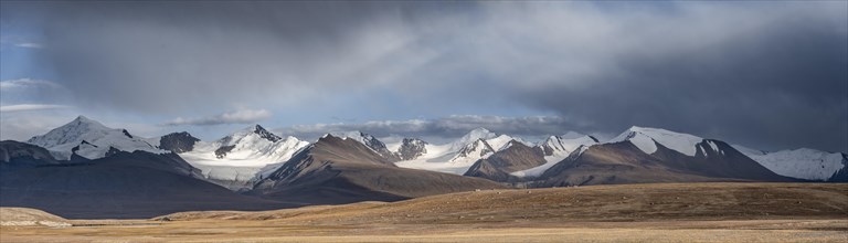 Autumnal plateau with brown grass, glaciated and snow-covered peaks, Kumtor Glacier and Sary-Tor