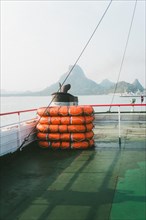 Calm waterscape with bundled lifebuoys on board a ship. Surat Thani, Thailand, Asia