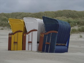 Close-up of colourful beach chairs standing in the dunes in cloudy weather, colourful beach chairs