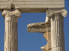 Close-up of ancient columns with decorated structure against blue sky, historical columns and ruins