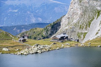Obstanserseehuette, Obstansersee mountain lake between green mountain meadows, Carnic main ridge,