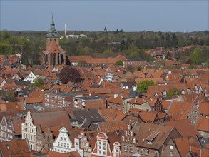 Historic old town with tiled roofs and church in spring atmosphere, surrounded by nature, red house