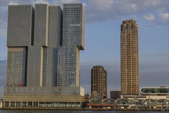 Two modern buildings in daylight, one of them very slim, skyline of a modern city on the river with
