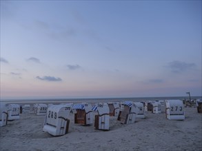 Several empty beach chairs on a quiet beach in the evening light and peaceful atmosphere, setting