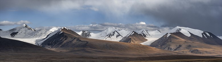 Autumnal plateau with brown grass, glaciated and snow-covered peaks, Kumtor Glacier and Sary-Tor
