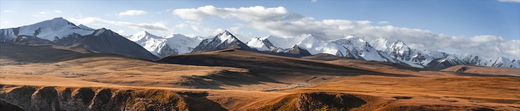 Panorama, Glaciated and snow-covered mountains, autumnal plateau with yellow grass in the morning