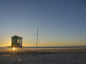 A beach hut at sunrise with a quiet atmosphere and a wide view of the sea, sunset on a beach with