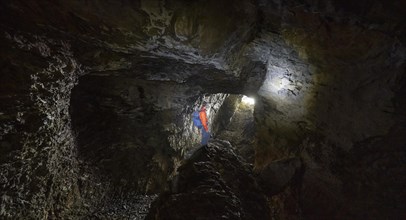 Hiker explores Obstans ice cave in Alta Pusteria, Carnic Alps, East Tyrol, Austria, Europe