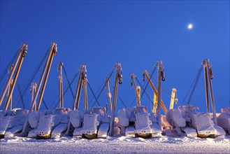 Cranes and equipment for oil production in the snow, twilight, Deadhorse, Alaska, USA, North