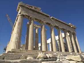 Close-up of the Parthenon with its classical columns under a clear sky, historical columns and