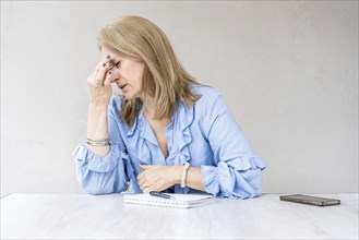 Tired woman stopped work to touching forehead because of a headache