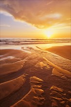 Atlantic ocean sunset with surging waves at Fonte da Telha beach, Costa da Caparica, Portugal,