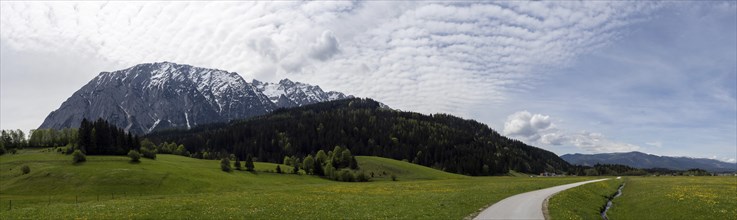 Salzkammergut cycle path leads through a meadow, cloudy mood over the Grimming, panoramic shot,