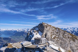 Futuristic building on a snow-covered mountain peak under a clear blue sky, Pilatus, Lucerne,