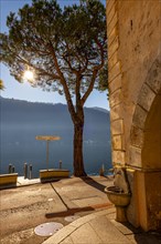 Old Beautiful Town with Building and Tree on the Waterfront on Lake Lugano with Sunbeam in a Sunny