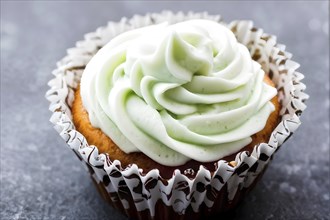 Cupcake with frosting swirls peaking like subtle ocean waves against grey background, AI generated