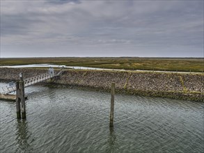 View of a coastal landscape with a long jetty and a cloudy sky, small jetty with a single-seater