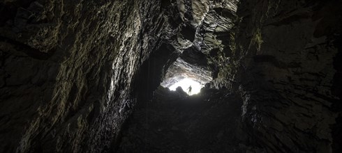 Hiker explores Obstans ice cave in Alta Pusteria, Carnic Alps, East Tyrol, Austria, Europe