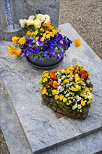 Grave with floral decoration at the cemetery church of St Stephan, Irsee, Swabia, Bavaria, Germany,