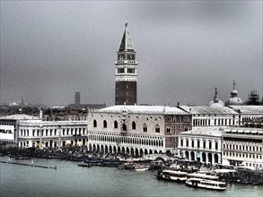 A view of the Campanile and surrounding buildings in Venice, with gondolas in the water on a cloudy