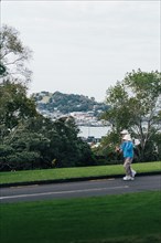 Partners enjoy evening walk in the park with views of the bay and nature in Auckland, New Zealand,