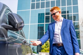 Businessman opening the door of a car after work in the city