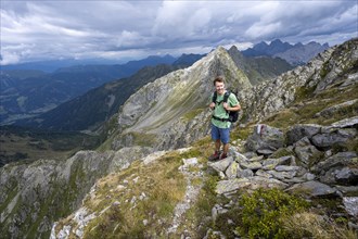 Mountaineer on mountain path, view of mountain panorama with Lesachtal valley, ascent to