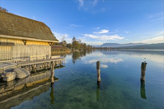 Boathouse on Lake Sempach with reflection in the water and clear sky, Sempach, Lucerne,