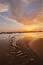 Atlantic ocean sunset with surging waves at Fonte da Telha beach, Costa da Caparica, Portugal,