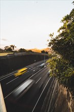 Sunset behind a motorway with a blurred yellow car. Madeira, Portugal, Europe