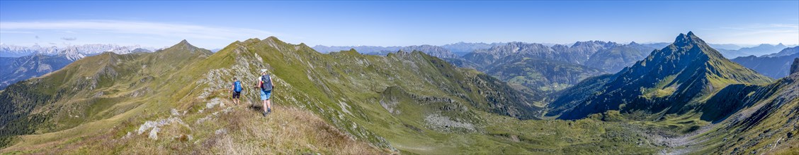 Panorama, mountaineer on a grassy ridge, view of the Lesach Valley and mountain panorama, Carnic