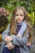 Outdoor portrait of cute little girl in coat and scarf