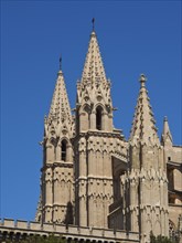 Two gothic towers of a cathedral under a clear blue sky, detailed architecture, beautiful cathedral