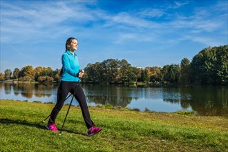 Nordic walking adventure and exercising concept, woman hiking with nordic walking poles in park