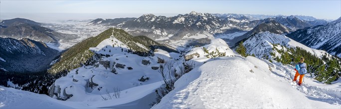 Hiker in winter climbing the Aiplspitz, winter, Alpine panorama with Aiplspitz, Schliersee and