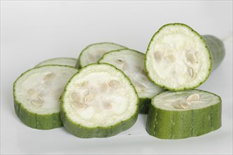 Sponge cucumber or sponge pumpkin (Luffa aegyptiaca, Luffa cylindrica), sliced fruit on a white