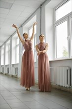 Two ballet dancers rehearsing choreography in the hallway