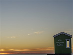 Sunset on the beach with green beach hut and wide sky, beautiful sunset on the beach of an island