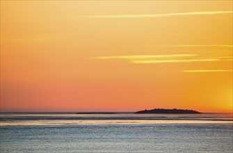 Sky and sea at a picturesque, golden, breathtakingly beautiful sunset over the sea, island