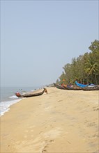 Indian fishermen pushing their boat into the sea, Cherai Beach or beach, Vypin Island, Kochi,