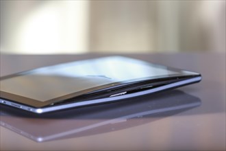 A defective, swollen battery pushes the housing of a tablet apart, damaging the display