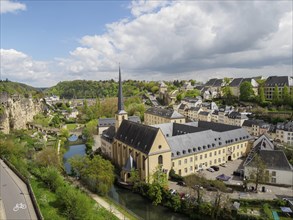 Panorama of the city with a church and a river, surrounded by historic buildings and green hills