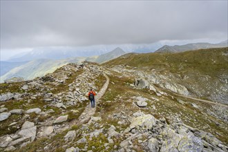 Mountaineers on a hiking trail descending to the Obstanserseehuette, Carnic Main Ridge, Carnic High